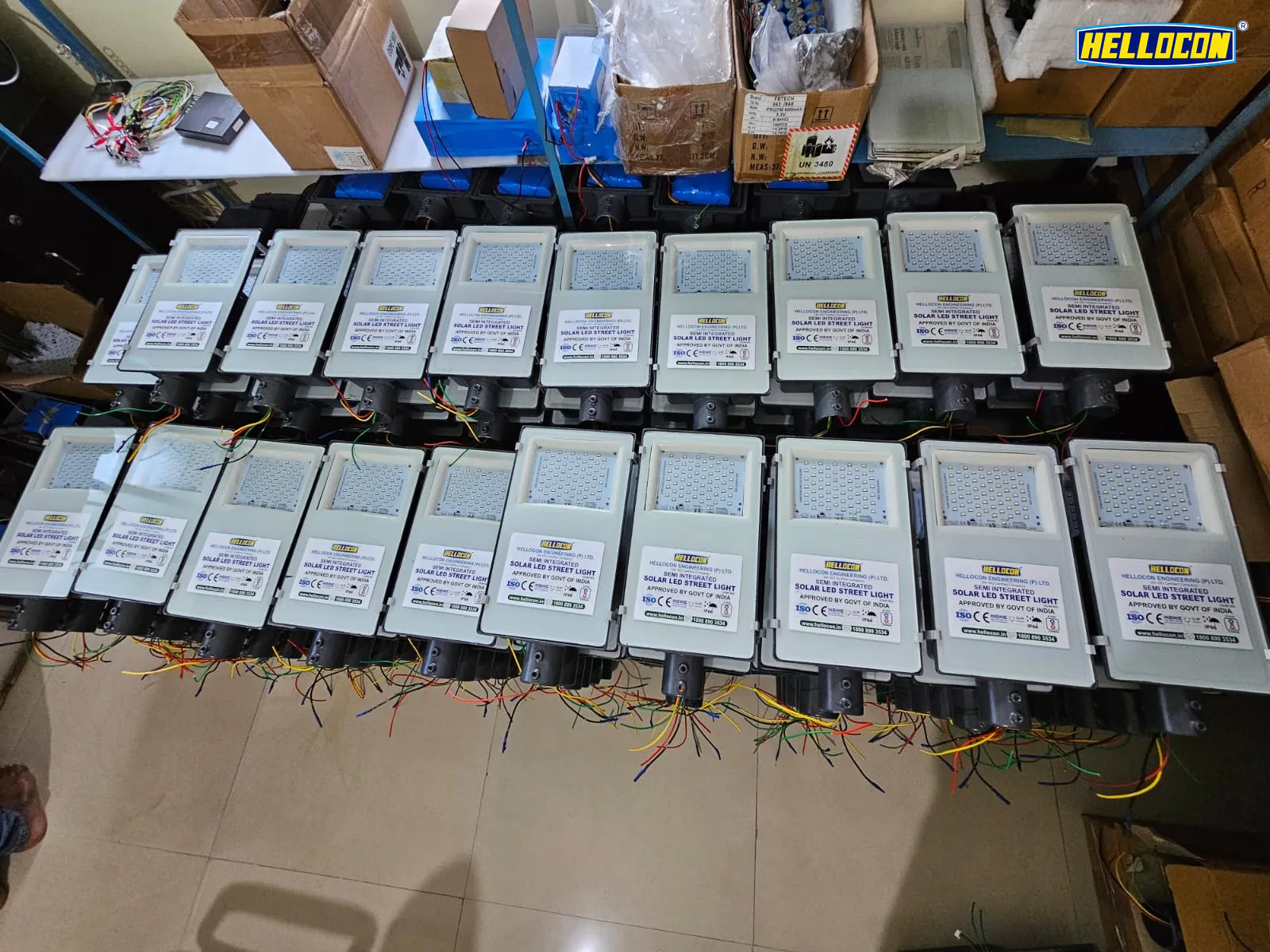 Two rows of HELLOCON semi-integrated solar LED street light luminaires laid out with their wiring