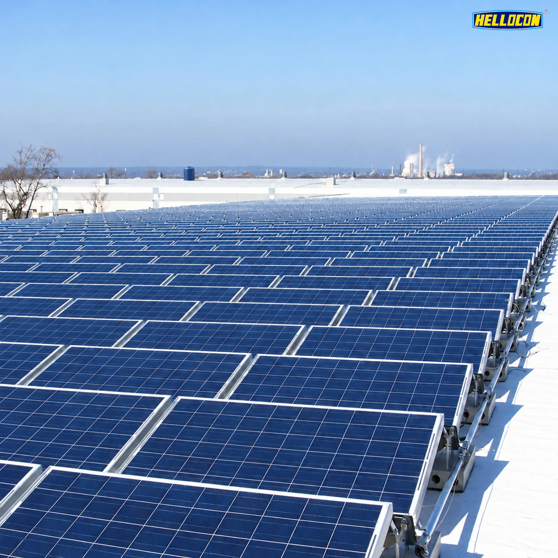 Polycrystalline panels on ballasted racks across a white factory roof at the HELLOCON 660 kWp plant in Angul