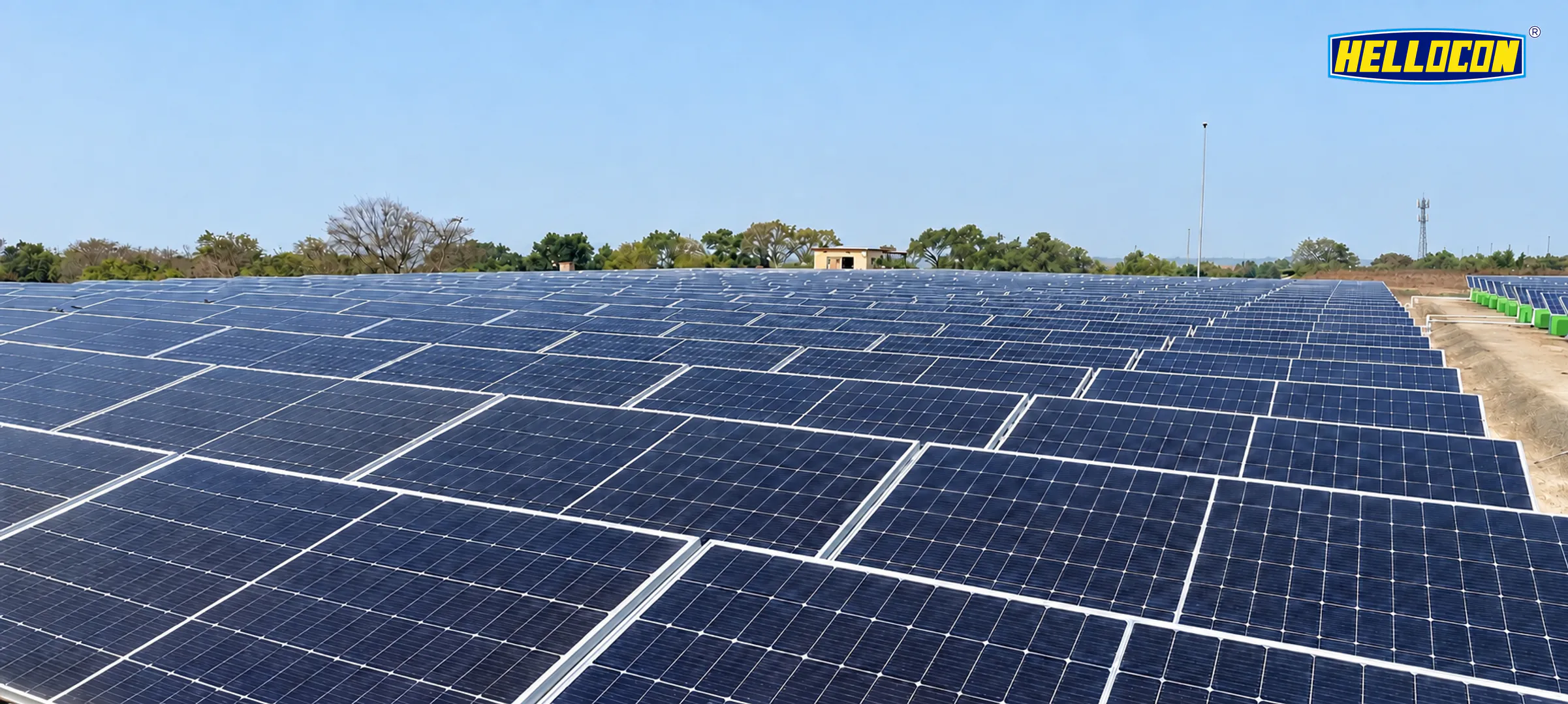 HELLOCON 250 kWp solar power plant in Ganjam: rows of ground-mounted panel tables stretching to a tree line